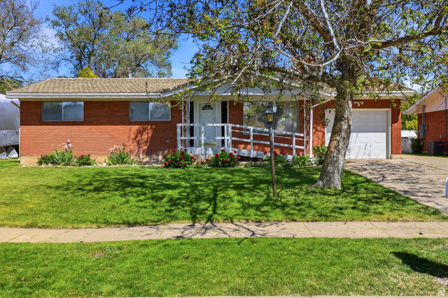 2348 North 770 West Clinton, UT 84015 - Photo 1 of 25 Brick ranch-style residence featuring a well-maintained lawn, a front entry with a ramp, and an attached single-car garage