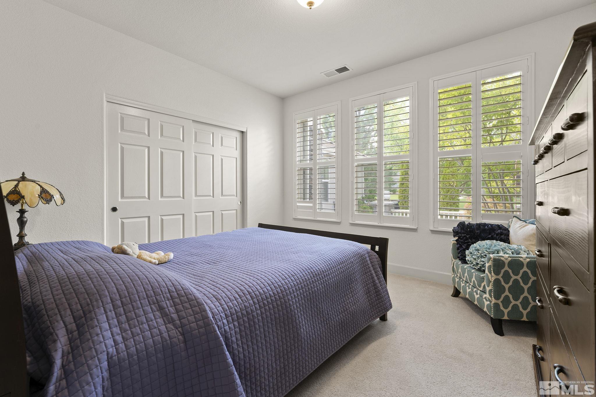 8150 Willow Ranch Trail Reno, NV 89523 - Photo 21 of 32 a bedroom with a bed couches chair and a large window