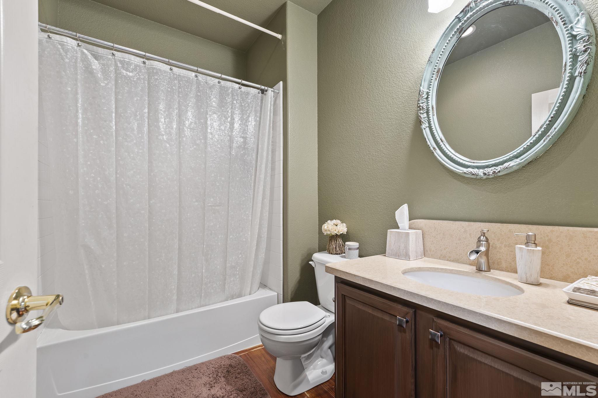 8150 Willow Ranch Trail Reno, NV 89523 - Photo 22 of 32 a bathroom with a sink a toilet and a mirror