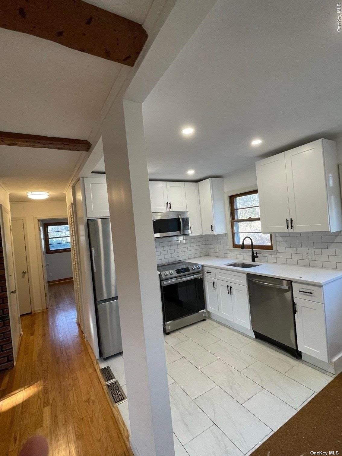 a large kitchen with stainless steel appliances granite countertop a stove refrigerator and a sink