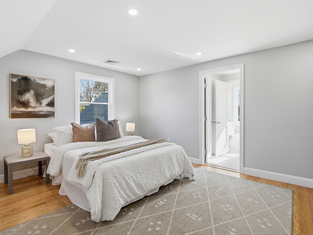 58 Maple Street Framingham, MA 01702 - Photo 16 of 35 a spacious bedroom with a bed and a painting on the wall