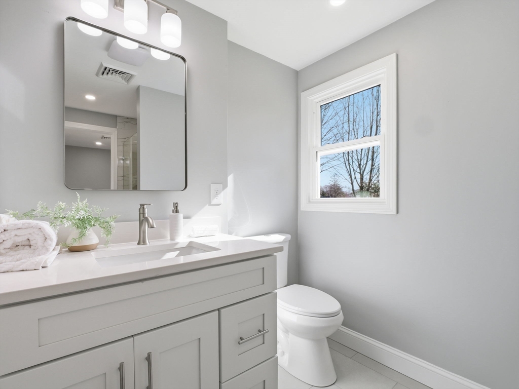 58 Maple Street Framingham, MA 01702 - Photo 22 of 35 a bathroom with a granite countertop toilet sink and mirror