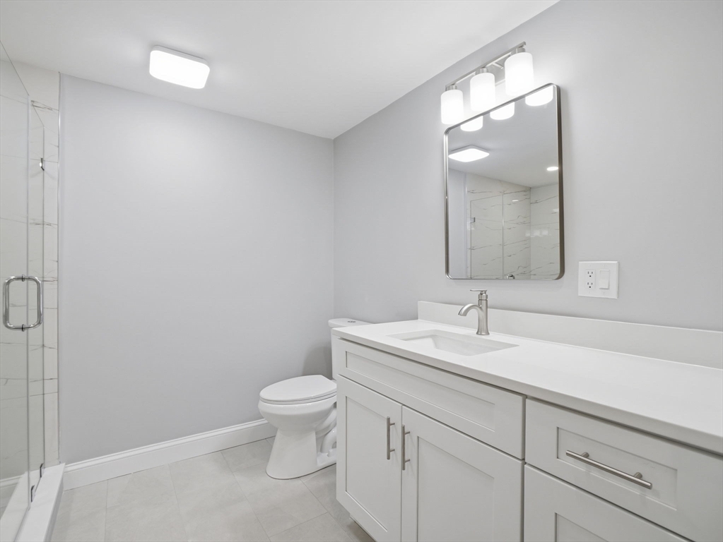 58 Maple Street Framingham, MA 01702 - Photo 28 of 35 a bathroom with a toilet a sink and mirror