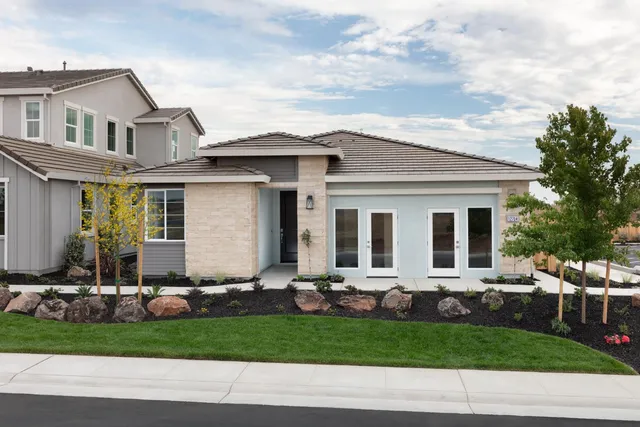 a front view of a house with a yard and outdoor seating