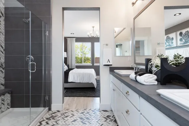 a en suite bathroom with a double vanity sink a mirror and shower