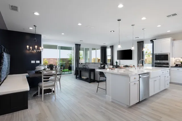 a large kitchen with kitchen island a dining table chairs and a wooden floor