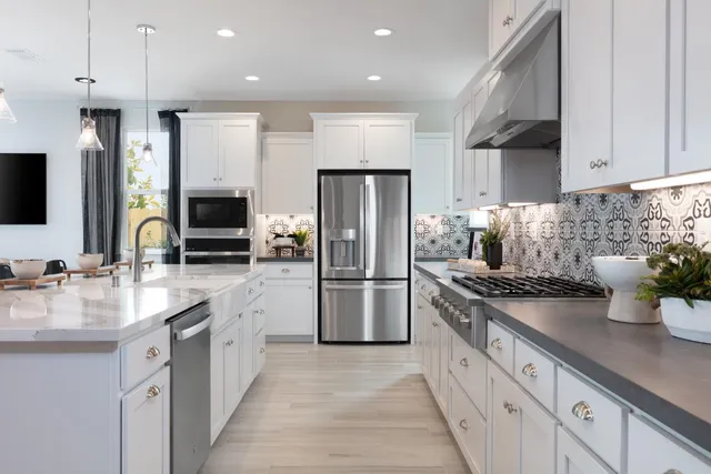 a kitchen with stainless steel appliances granite countertop a refrigerator a sink and a stove