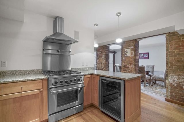 a kitchen with a stove and a wooden floor