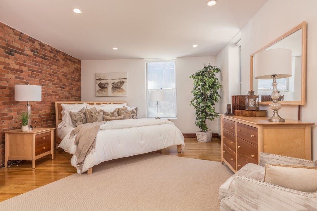 5 Durham Street, Unit 2 Boston, MA 02115 - Photo 14 of 22 a spacious bedroom with a large bed and potted plant