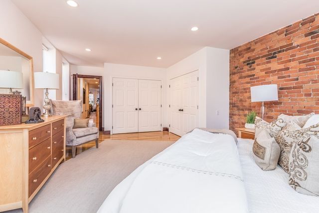 a spacious bedroom with a large bed and a dresser