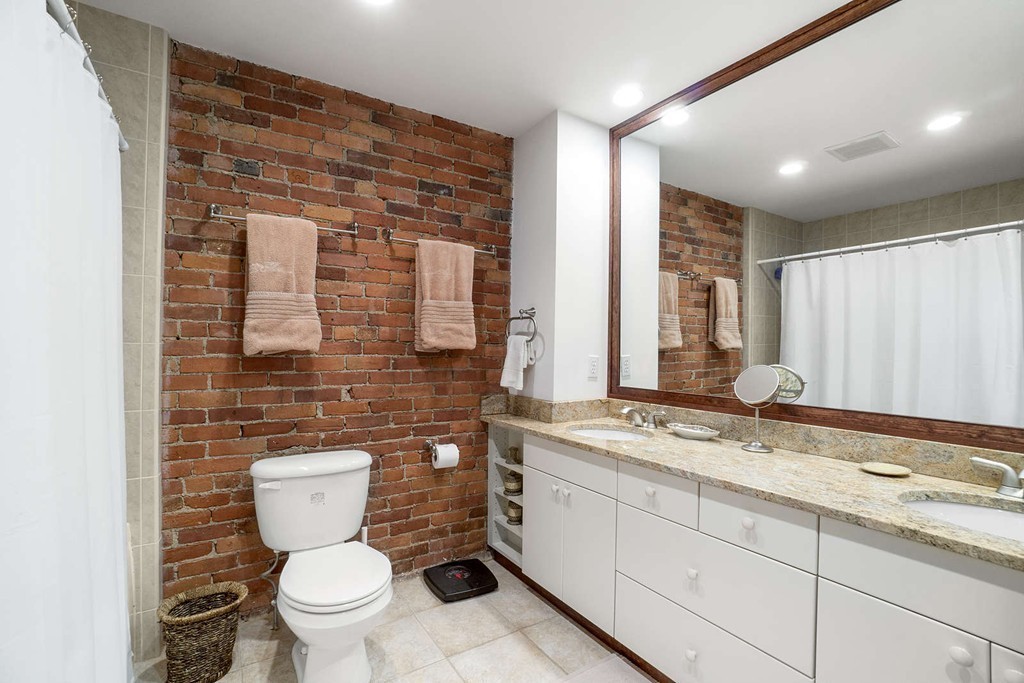 5 Durham Street, Unit 2 Boston, MA 02115 - Photo 18 of 22 a bathroom with a granite countertop toilet a sink and a large mirror