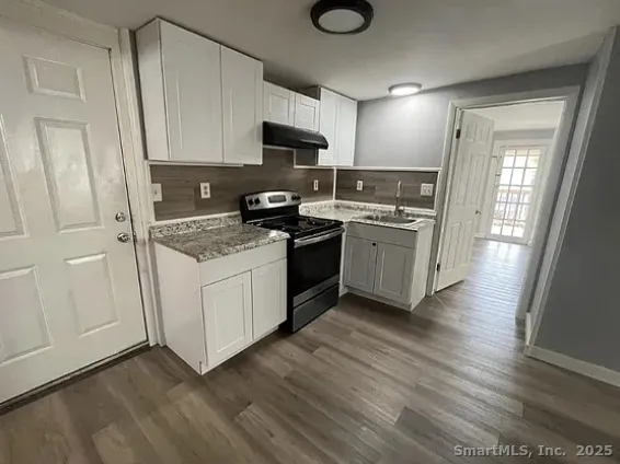 a kitchen with a sink a stove and cabinets