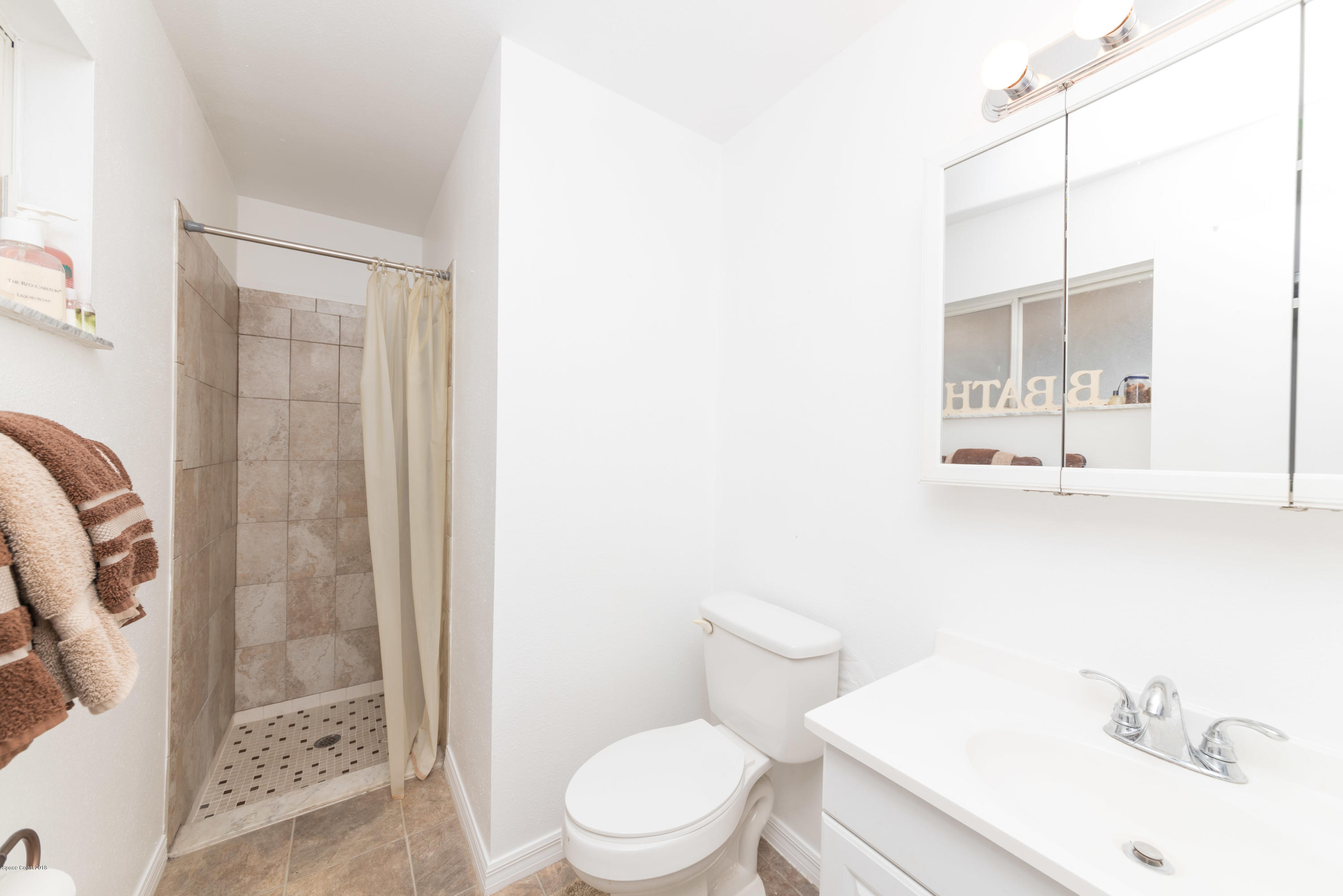 253 Chase Road Cocoa, FL 32927 - Photo 21 of 22 a white toilet sitting next to a bathroom sink