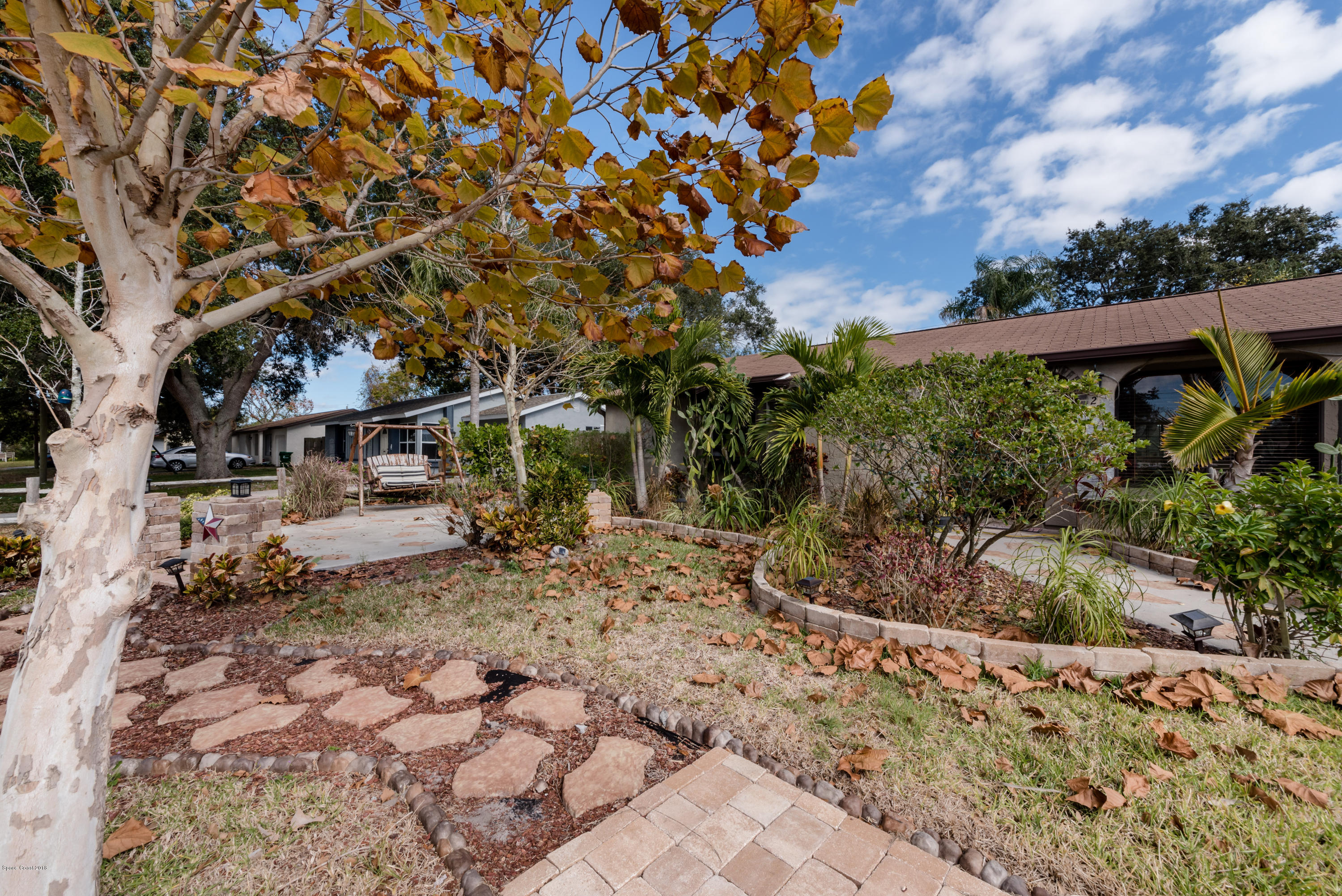 253 Chase Road Cocoa, FL 32927 - Photo 6 of 22 a view of a yard with plants and a bench