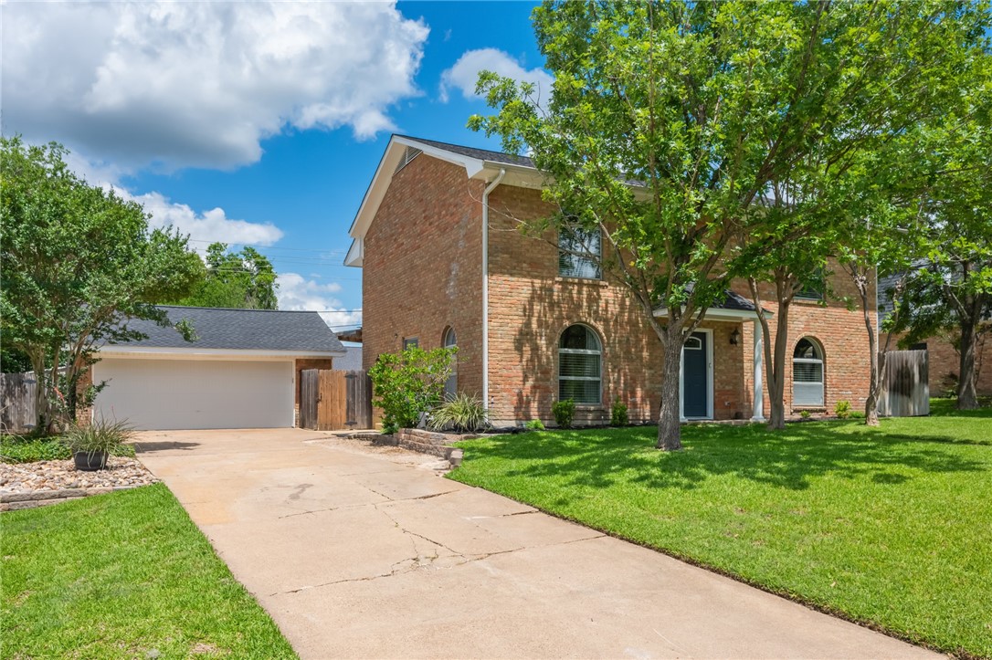 a front view of a house with a garden and trees