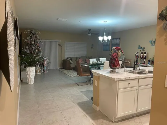 a living room with furniture a chandelier and a flat screen tv
