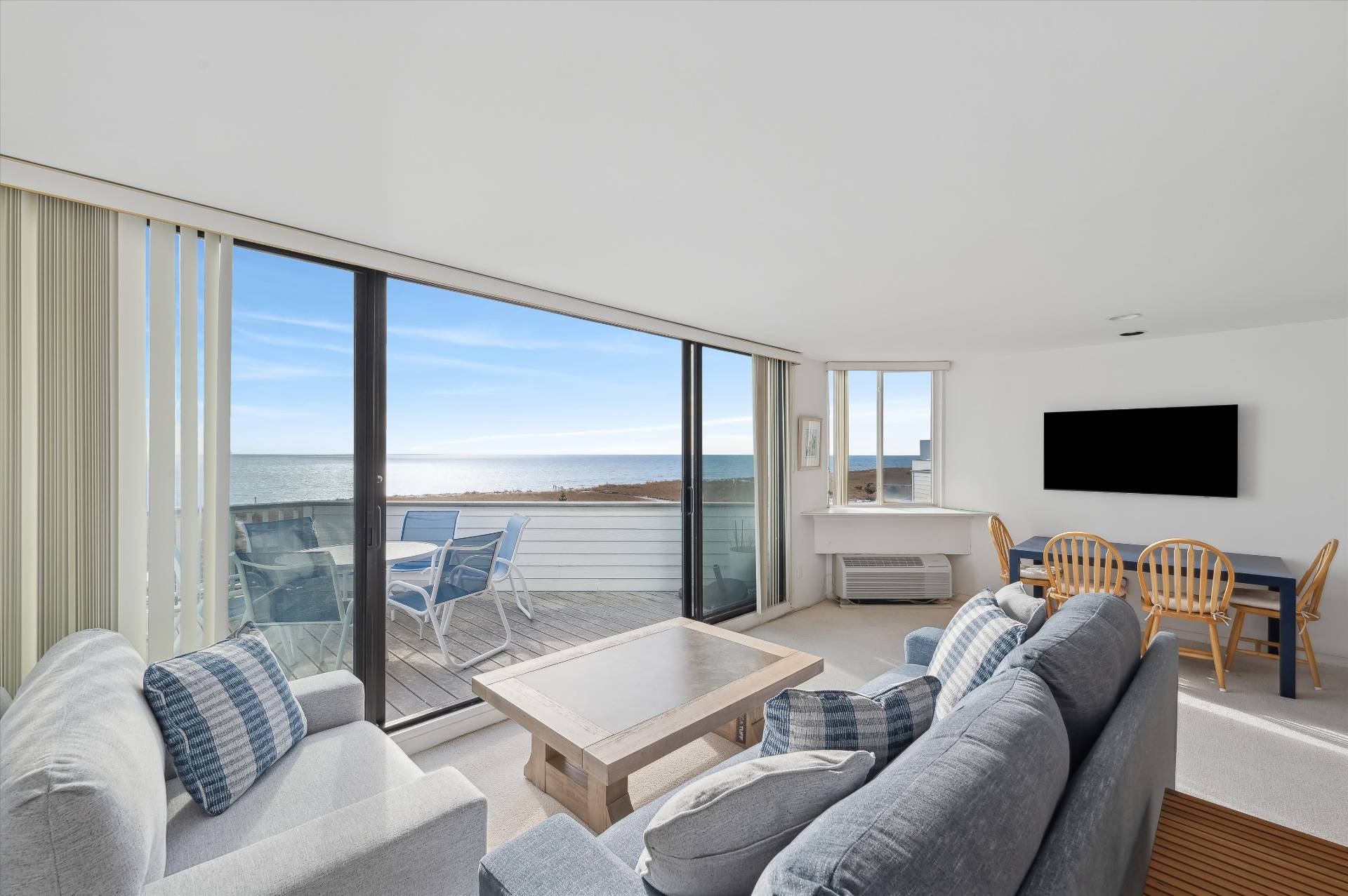 259 Dune Road, Unit 137 Westhampton Beach, NY 11978 - Photo 2 of 16 a living room with furniture and a flat screen tv