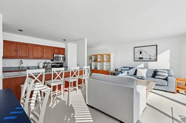 a view of a dining room with furniture a kitchen and chandelier