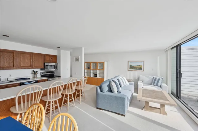 a living room with furniture kitchen view and a window
