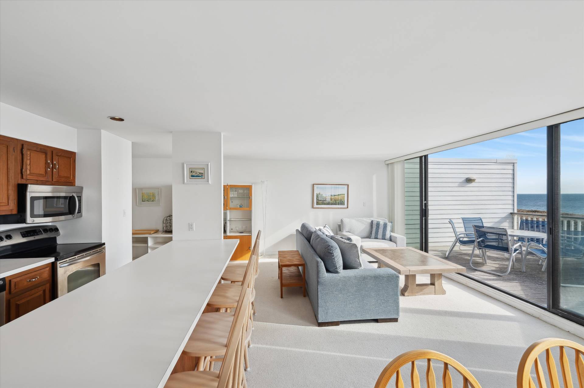 259 Dune Road, Unit 137 Westhampton Beach, NY 11978 - Photo 7 of 16 a living room with furniture and a flat screen tv