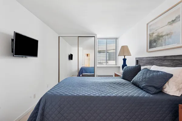 a bedroom with a bed and a flat screen tv