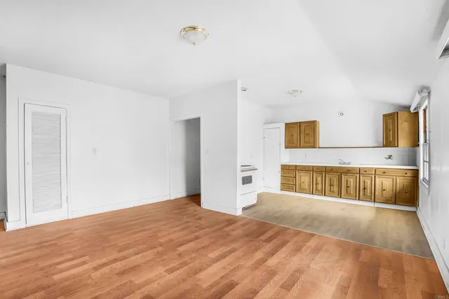 a view of a bedroom with wooden floor and a bed
