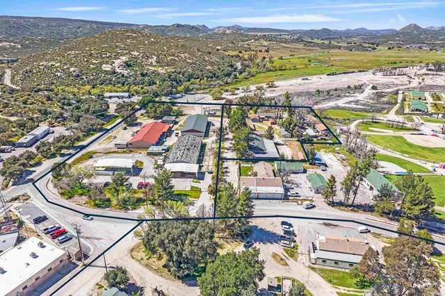 an aerial view of a city with lots of residential buildings and mountain view in back