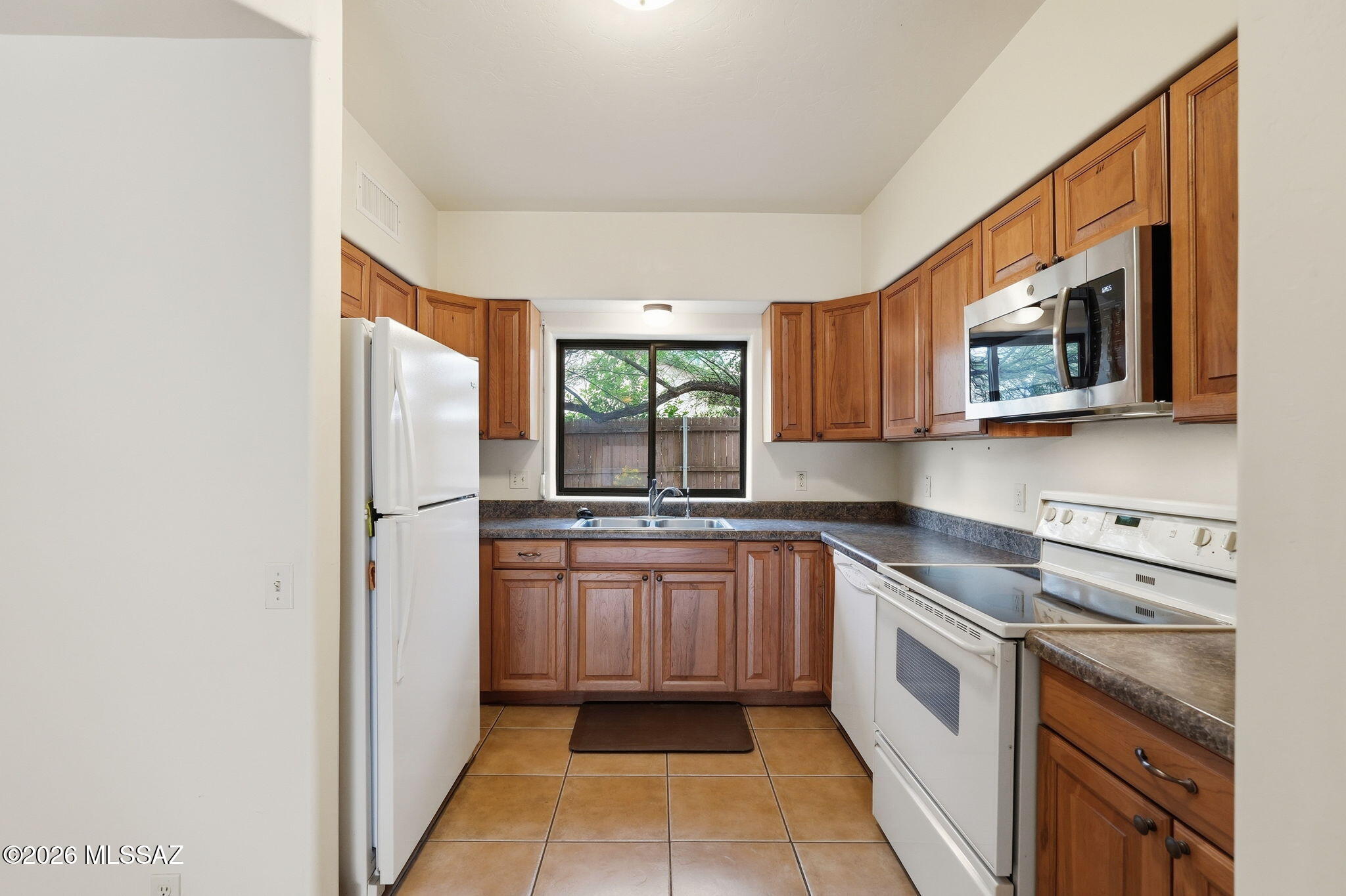 1125 East Kleindale Road Tucson, AZ 85719 - Photo 36 of 49 a kitchen with stainless steel appliances granite countertop a refrigerator microwave and sink