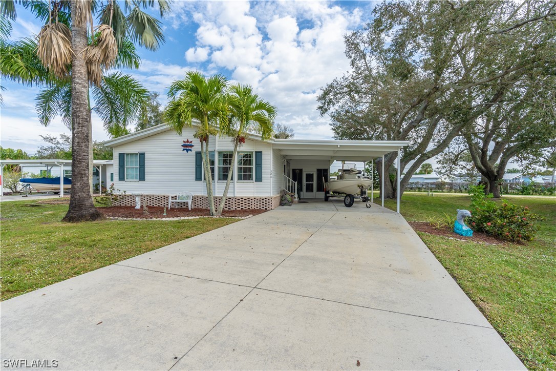 280 Riverwood Road Naples, FL 34114 - Photo 2 of 35 a view of a house with backyard and a tree