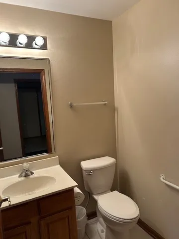 a bathroom with a toilet a sink and mirror