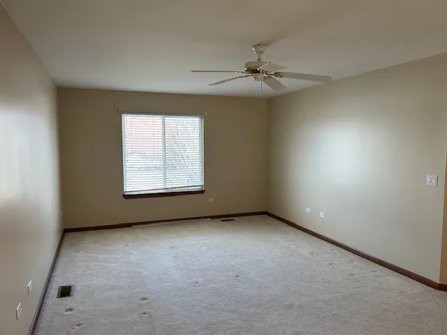 an empty room with a window and a fan