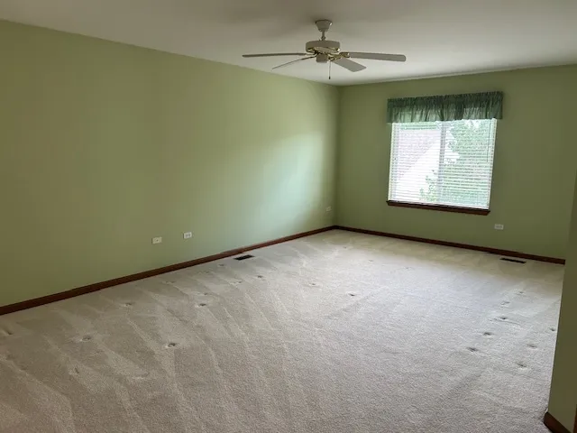 an empty room with a mirror and a fan