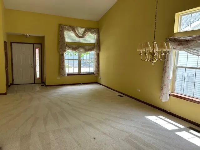 a view of a room with wooden floor a fireplace and windows