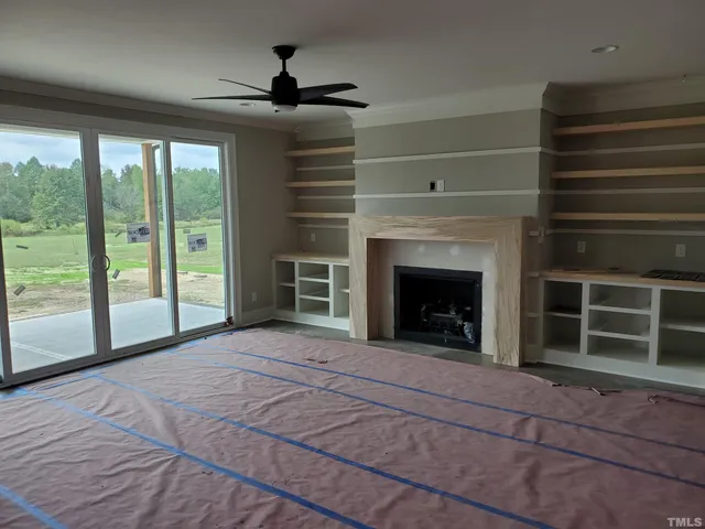 a view of an empty room with a fireplace and a window