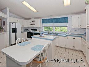 1197 Beaverdam Road Canton, NC 28716 - Photo 4 of 14 a kitchen with a stove a sink a refrigerator and a dining table