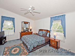 1197 Beaverdam Road Canton, NC 28716 - Photo 7 of 14 a bedroom with a bed and a chandelier