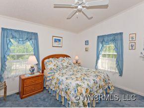1197 Beaverdam Road Canton, NC 28716 - Photo 9 of 14 a bedroom with a bed and a chandelier