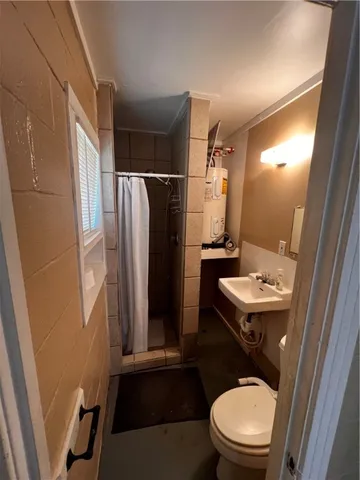 a bathroom with a sink a toilet a mirror and shower