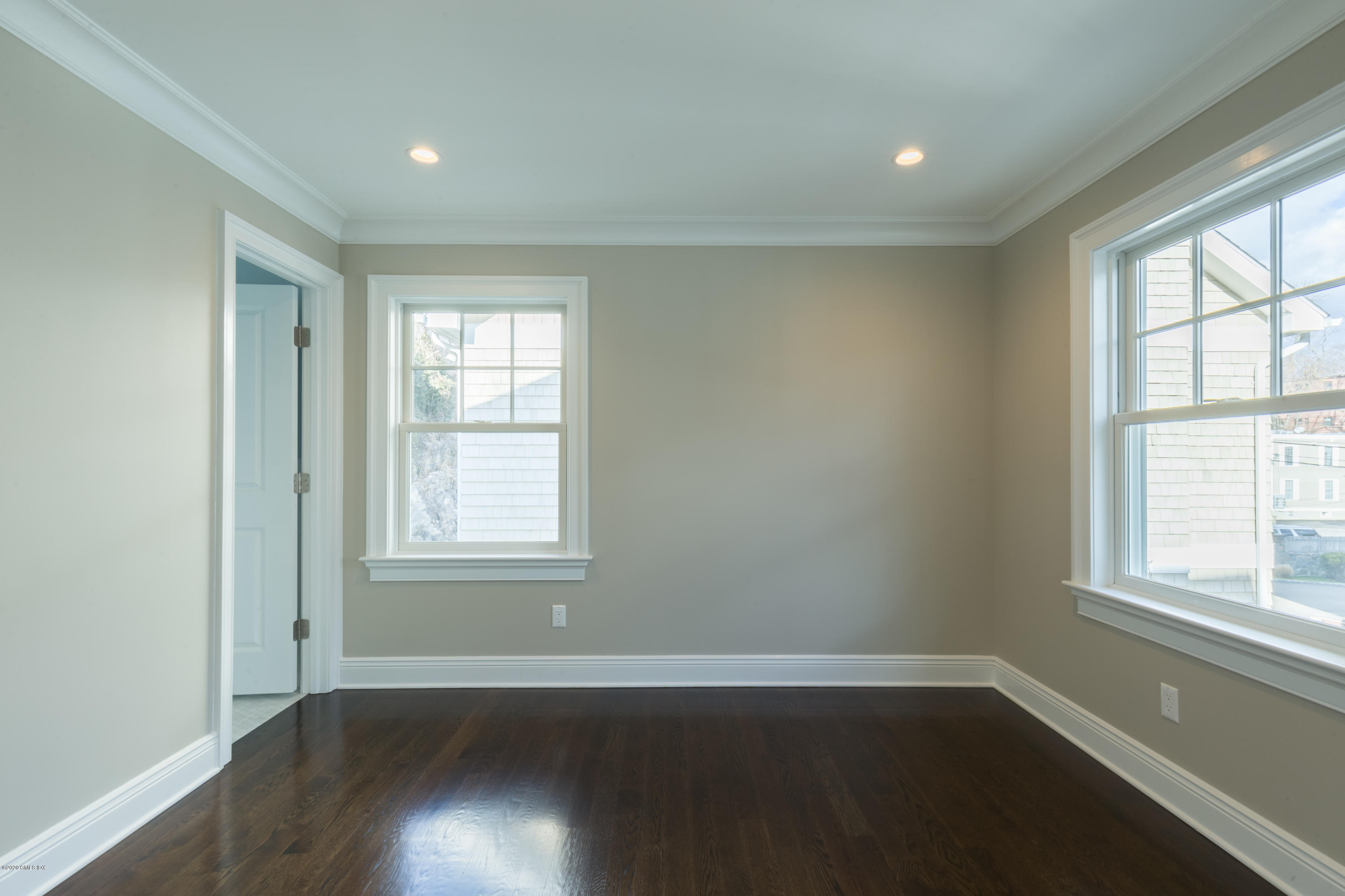 301 Davis Avenue, Unit B Greenwich, CT 06830 - Photo 11 of 16 an empty room with wooden floor and windows