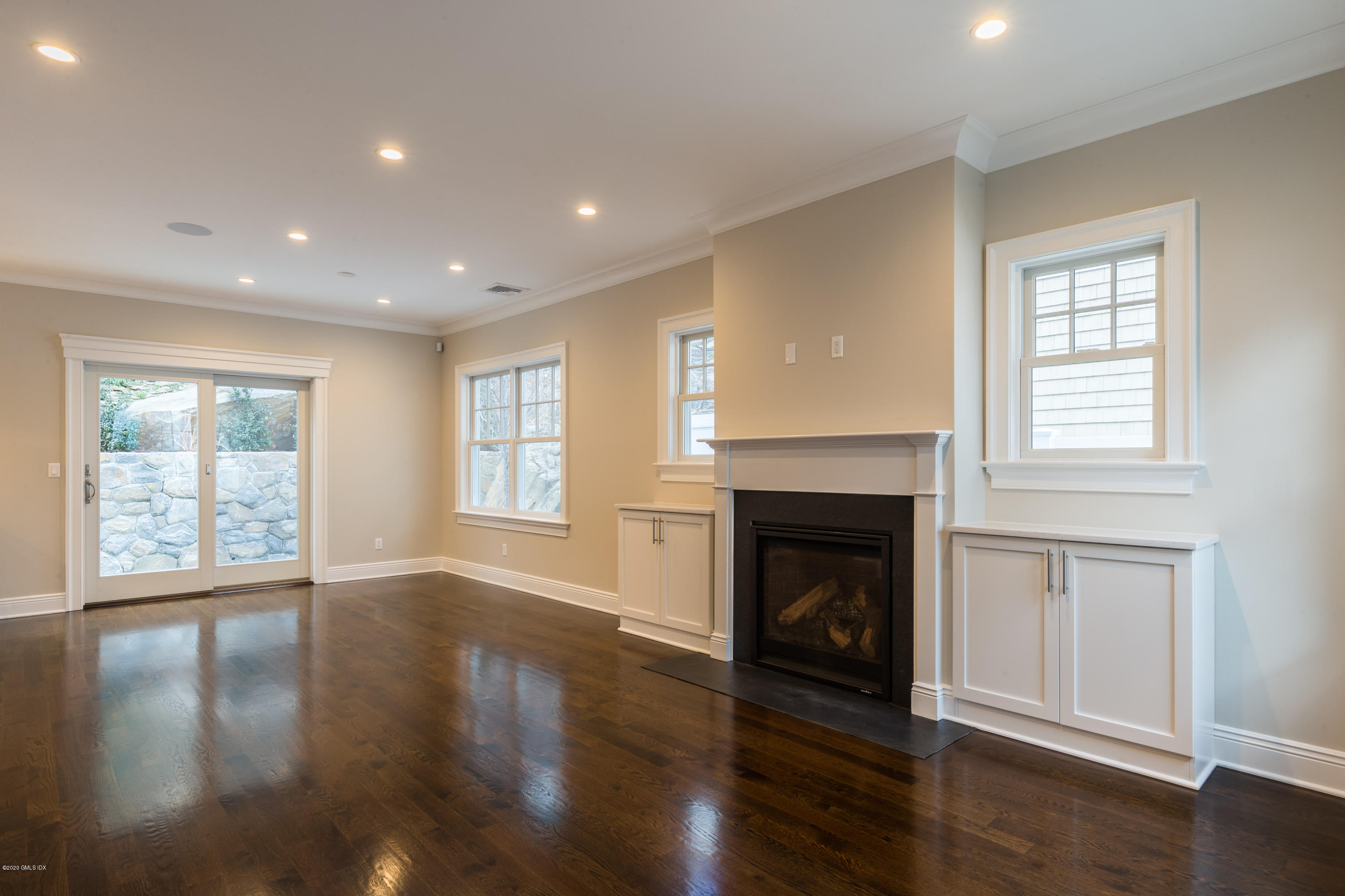 301 Davis Avenue, Unit B Greenwich, CT 06830 - Photo 3 of 16 a view of an empty room with wooden floor and a window