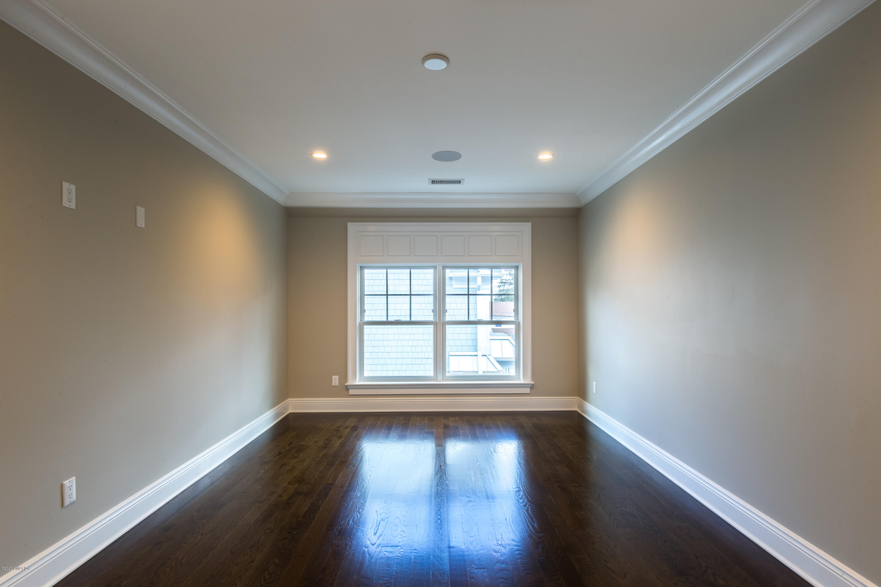 301 Davis Avenue, Unit B Greenwich, CT 06830 - Photo 9 of 16 an empty room with wooden floor and windows with curtains