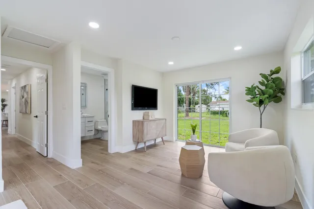 a living room with furniture floor to ceiling window a flat screen tv and a floor to ceiling window