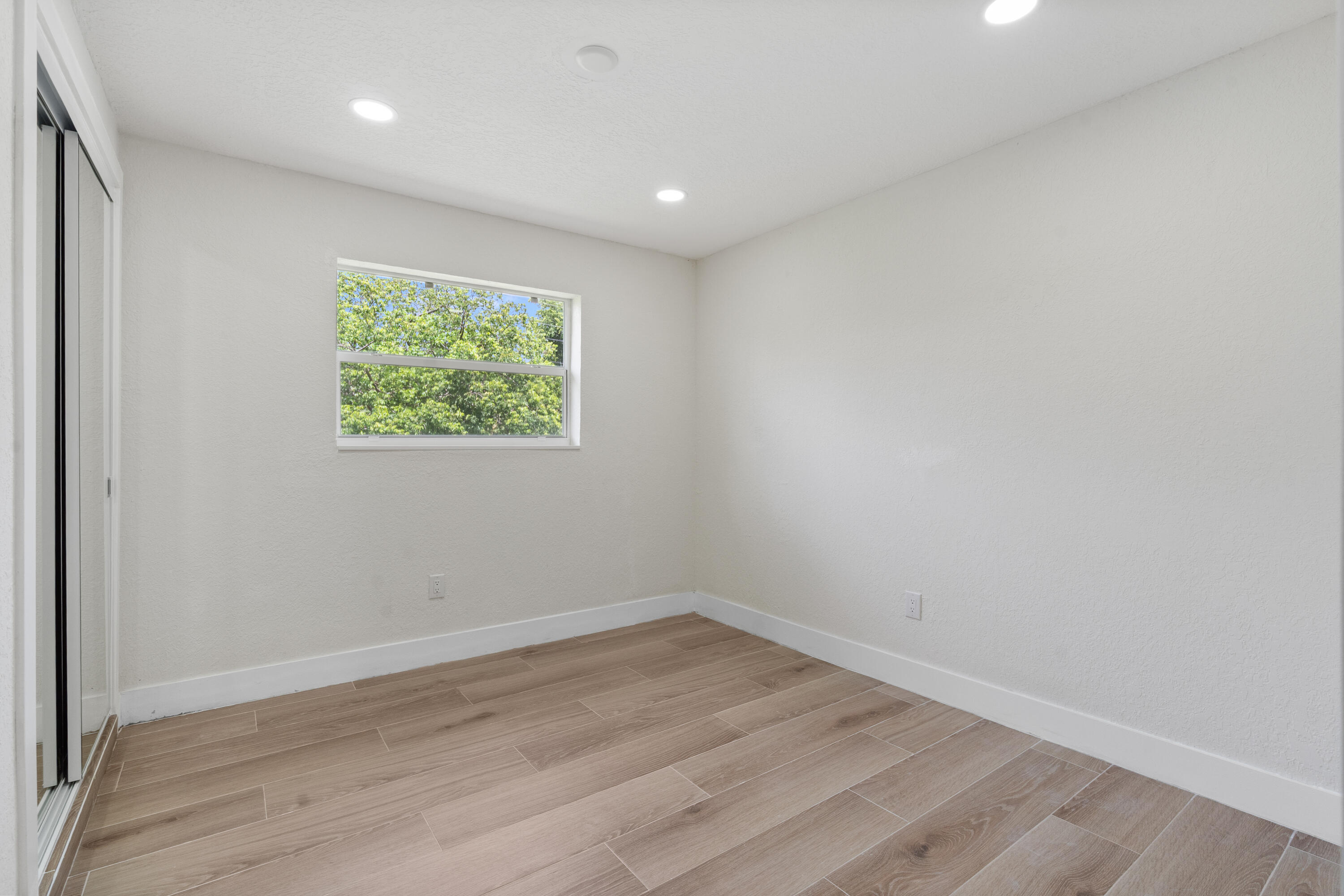 930 Rutherford Lane Haverhill, FL 33415 - Photo 17 of 25 a view of room with hardwood floor and window