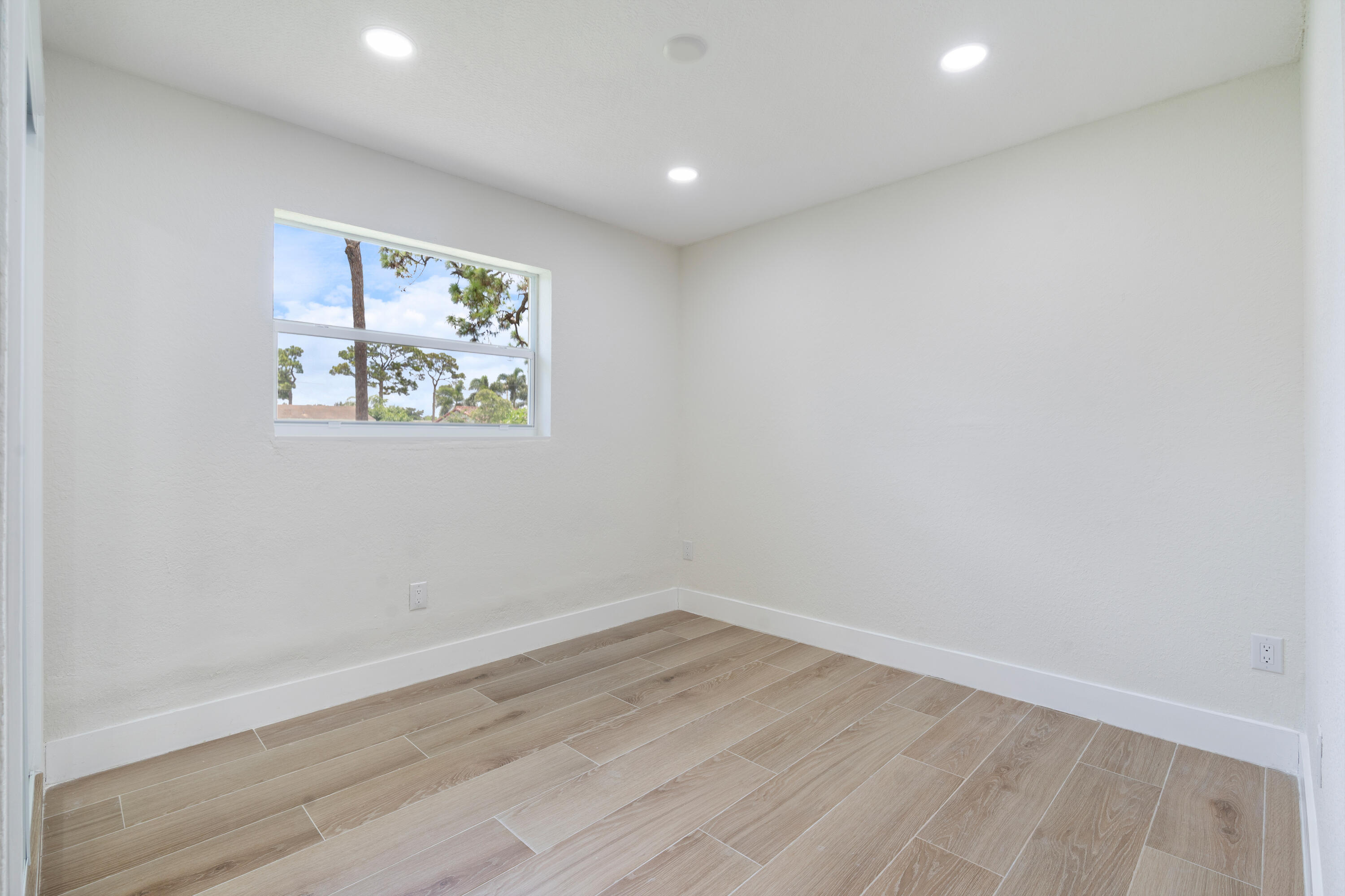 930 Rutherford Lane Haverhill, FL 33415 - Photo 21 of 25 an empty room with wooden floor and window