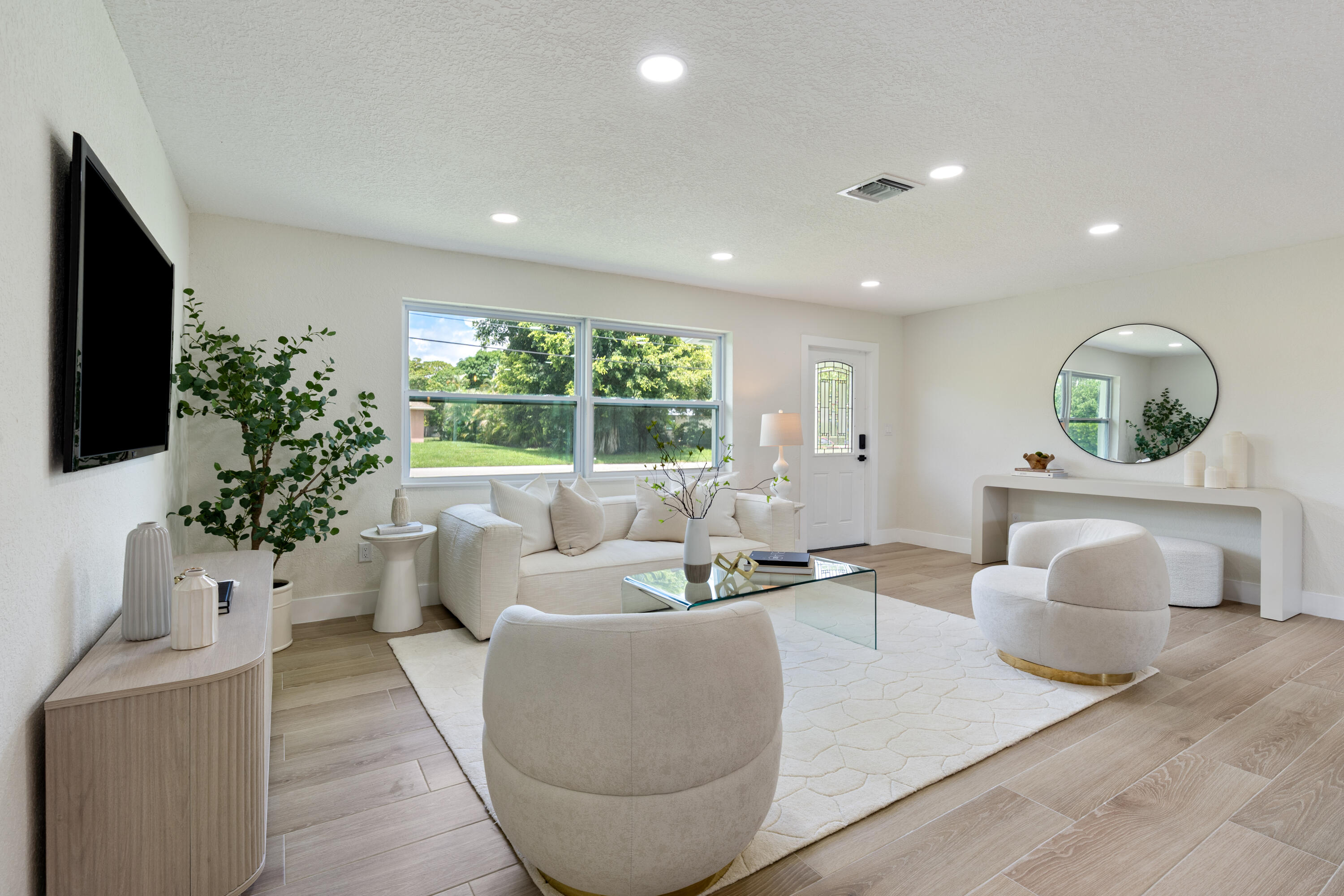 930 Rutherford Lane Haverhill, FL 33415 - Photo 4 of 25 a living room with furniture potted plant and a large window