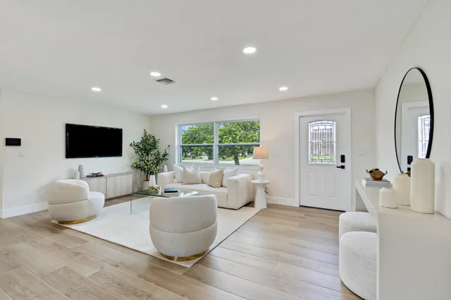 a living room with furniture a flat screen tv and a large window