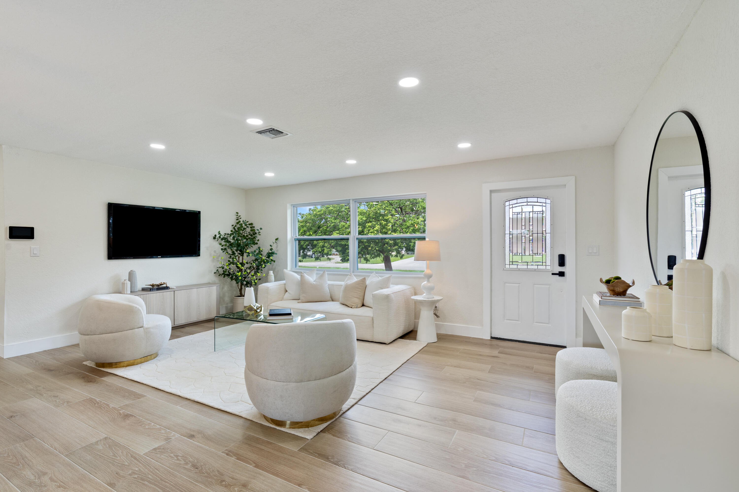 930 Rutherford Lane Haverhill, FL 33415 - Photo 5 of 25 a living room with furniture a flat screen tv and a large window