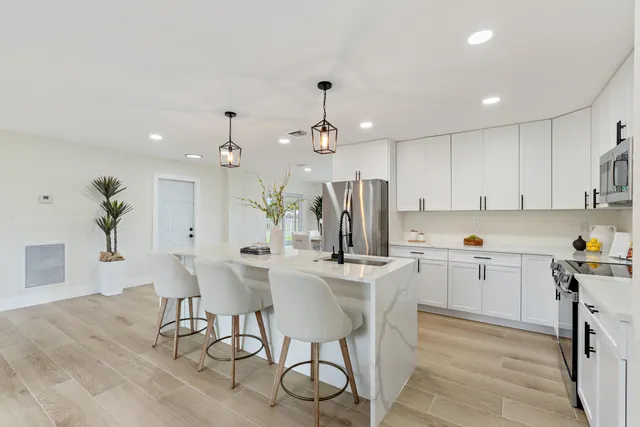 a kitchen with kitchen island a stove a table and chairs in it