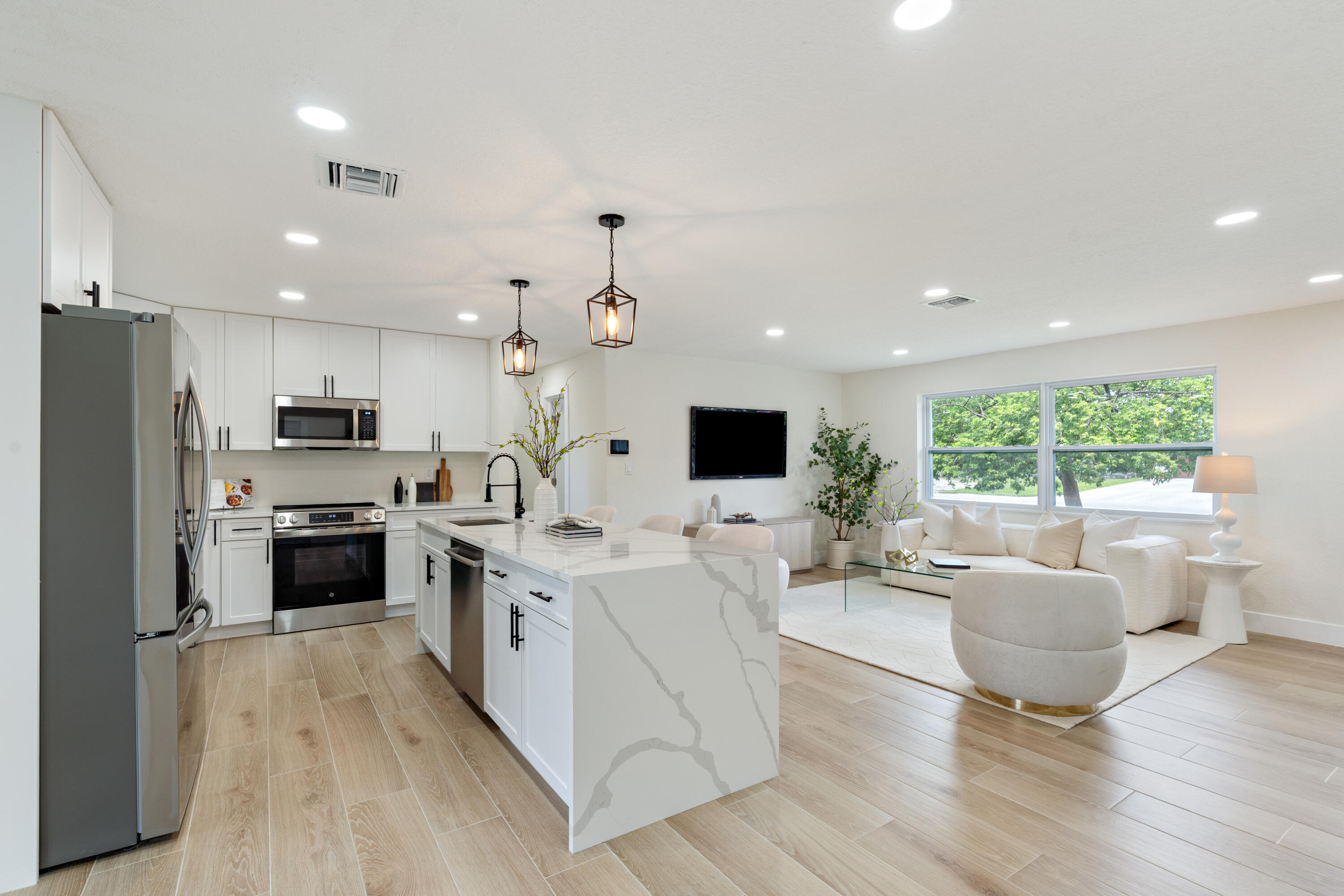930 Rutherford Lane Haverhill, FL 33415 - Photo 8 of 25 a large living room with stainless steel appliances kitchen island granite countertop a large window and a view of living room