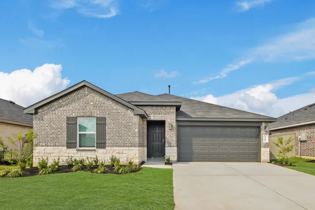 a front view of a house with a garden and yard